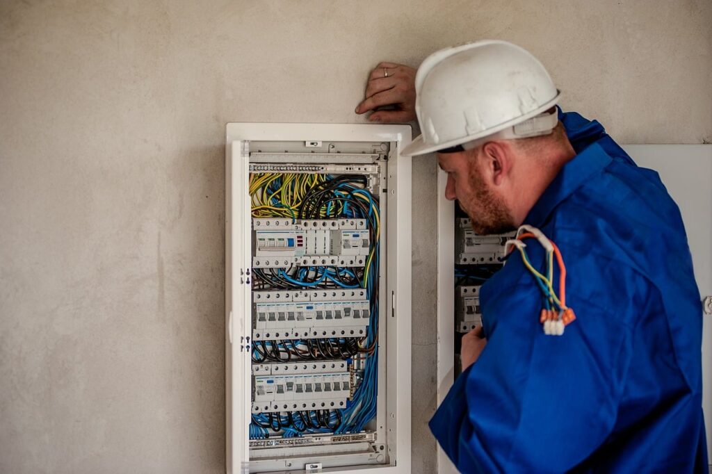 elektrikář zapojuje rozvodnou skříň s pojistkami
